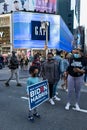 Young African American Boy Holding a Biden Harris Sign among Crowds of People in Times Square Celebrating after the Win of Presi