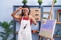 Young african american with braids at art studio painting on canvas smiling making frame with hands and fingers with happy face Royalty Free Stock Photo