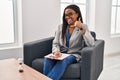 Young african american with braids working at consultation office smiling doing phone gesture with hand and fingers like talking Royalty Free Stock Photo