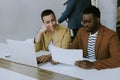 Young African American business man and short hair woman working on laptop while sitting at office Royalty Free Stock Photo