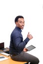 Young African American business man sitting on top of his desk in office Royalty Free Stock Photo