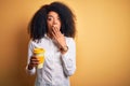 Young african american business woman with afro hair drinking coffee from take away cup cover mouth with hand shocked with shame