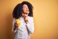 Young african american business woman with afro hair drinking coffee from take away cup serious face thinking about question, very Royalty Free Stock Photo