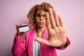Young african american business woman holding id card identification over pink background with open hand doing stop sign with Royalty Free Stock Photo