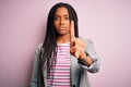 Young african american business woman standing over pink isolated background Pointing with finger up and angry expression, showing Royalty Free Stock Photo