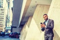 Young African American Businessman with beard, short hair, texting on cell phone outside in New York City