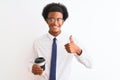 Young african american businessman drinking cup of coffee over isolated white background happy with big smile doing ok sign, thumb Royalty Free Stock Photo