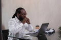 Young African American businessman feeling stressed and tired while working from home with documents stacked next to him Royalty Free Stock Photo