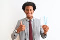 Young african american businessman holding boarding pass over isolated white background happy with big smile doing ok sign, thumb Royalty Free Stock Photo