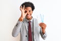 Young african american businessman holding boarding pass over isolated white background with happy face smiling doing ok sign with Royalty Free Stock Photo