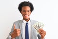 Young african american businessman holding dollars standing over isolated white background happy with big smile doing ok sign, Royalty Free Stock Photo