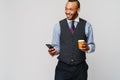 Young African-american Businessman holding Phone And Coffee to go over light grey background Royalty Free Stock Photo