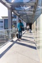 Young african american businessman with luggage walking ahead of businesswoman at airport corridor Royalty Free Stock Photo