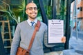 Young african american businessman smiling happy holding clipboard with agreement document at the city Royalty Free Stock Photo