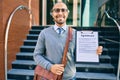 Young african american businessman smiling happy holding clipboard with agreement document at the city Royalty Free Stock Photo