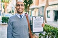 Young african american businessman smiling happy holding clipboard with agreement document at the city Royalty Free Stock Photo