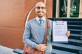 Young african american businessman smiling happy holding clipboard with agreement document at the city Royalty Free Stock Photo