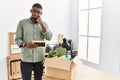 Young african american businessman unboxing box at the office with hand on chin thinking about question, pensive expression Royalty Free Stock Photo