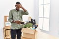 Young african american businessman unboxing box at the office peeking in shock covering face and eyes with hand, looking through Royalty Free Stock Photo