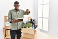 Young african american businessman unboxing box at the office pointing down looking sad and upset, indicating direction with Royalty Free Stock Photo