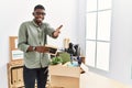 Young african american businessman unboxing box at the office smiling friendly offering handshake as greeting and welcoming Royalty Free Stock Photo