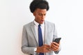 Young african american businessman using smartphone over isolated white background scared in shock with a surprise face, afraid Royalty Free Stock Photo