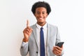 Young african american businessman using smartphone over isolated white background surprised with an idea or question pointing Royalty Free Stock Photo