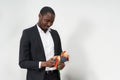 Young african american businessman wearing suit holding gift. present concept Royalty Free Stock Photo