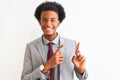 Young african american businessman wearing suit standing over isolated white background smiling and looking at the camera pointing Royalty Free Stock Photo