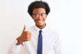 Young african american businessman wearing tie and glasses over isolated white background doing happy thumbs up gesture with hand Royalty Free Stock Photo