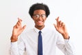 Young african american businessman wearing tie and glasses over isolated white background gesturing finger crossed smiling with