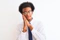 Young african american businessman wearing tie and glasses over isolated white background sleeping tired dreaming and posing with Royalty Free Stock Photo