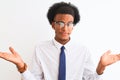 Young african american businessman wearing tie and glasses over  white background clueless and confused expression with Royalty Free Stock Photo
