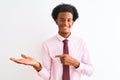 Young african american businessman wearing tie standing over isolated white background amazed and smiling to the camera while Royalty Free Stock Photo