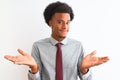 Young african american businessman wearing tie standing over isolated white background clueless and confused expression with arms Royalty Free Stock Photo