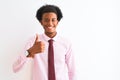 Young african american businessman wearing tie standing over isolated white background doing happy thumbs up gesture with hand Royalty Free Stock Photo