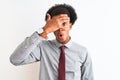 Young african american businessman wearing tie standing over isolated white background peeking in shock covering face and eyes Royalty Free Stock Photo