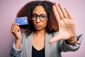 Young african american businesswoman with afro hair holding credit card over pink background with open hand doing stop sign with Royalty Free Stock Photo