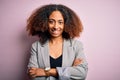 Young african american businesswoman with afro hair wearing elegant jacket happy face smiling with crossed arms looking at the Royalty Free Stock Photo