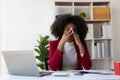 Young african american businesswoman thinking and stressed while working on laptop and financial documents Royalty Free Stock Photo