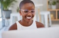 Young african american businesswoman wearing glasses, smiling and working on a computer in an office. One female only Royalty Free Stock Photo