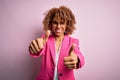 Young african american businesswoman wearing glasses standing over pink background approving doing positive gesture with hand, Royalty Free Stock Photo