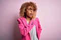 Young african american businesswoman wearing glasses standing over pink background hand on mouth telling secret rumor, whispering Royalty Free Stock Photo