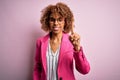 Young african american businesswoman wearing glasses standing over pink background pointing finger up with successful idea Royalty Free Stock Photo