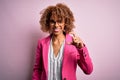 Young african american businesswoman wearing glasses standing over pink background smiling and confident gesturing with hand doing Royalty Free Stock Photo