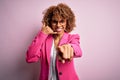 Young african american businesswoman wearing glasses standing over pink background smiling doing talking on the telephone gesture Royalty Free Stock Photo