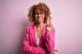 Young african american businesswoman wearing glasses standing over pink background smiling with happy face winking at the camera Royalty Free Stock Photo