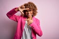 Young african american businesswoman wearing glasses standing over pink background smiling making frame with hands and fingers Royalty Free Stock Photo