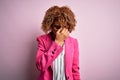 Young african american businesswoman wearing glasses standing over pink background tired rubbing nose and eyes feeling fatigue and