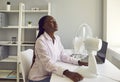 Young african american woman working at office using electric fan during heatwave in office. Royalty Free Stock Photo